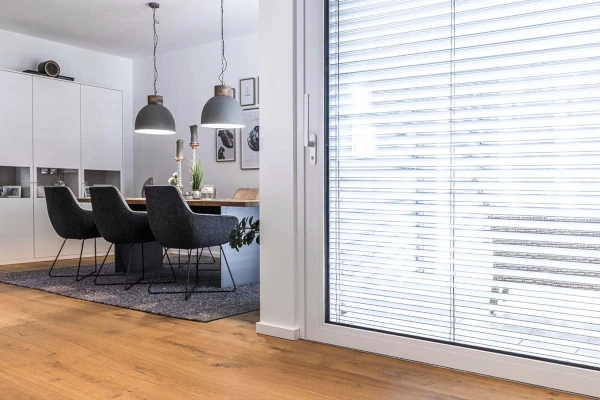 Esszimmer mit Esstisch und Stühlen, daneben Terrassentür zum Garten